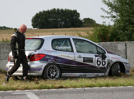 Anders Christensen kigger på skaderne på sin Peugeot 307 efter den hårdhændede behandling han fik fra konkurrentens side.